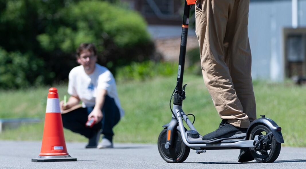 Persona utilizando un monopatín eléctrico en una calle urbana.